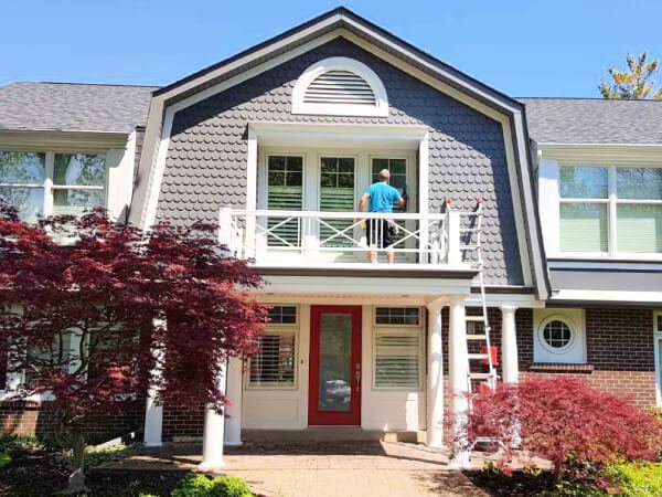 Professional window cleaner at work on the second floor of a residential house in PEI