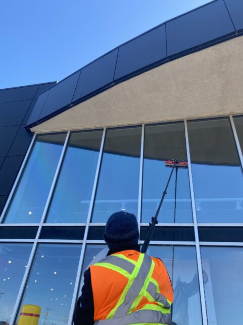 High-reach water-fed pole cleaning at a shopping mall entrance in Charlottetown.